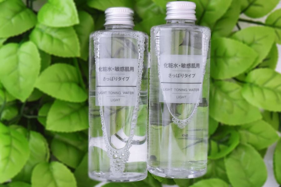 Hai chai nước làm dịu da trong suốt, nền lá xanh tươi.