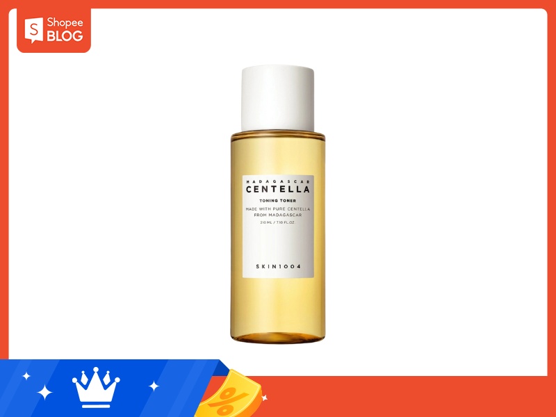Chai toner màu vàng, nhãn trắng, nền trắng, viền đỏ với logo Shopee Blog góc trên bên trái.
