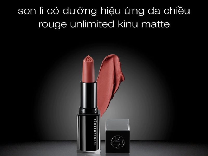 0b121be7-review-son-shu-uemura-2 Thỏi son màu đỏ đất, chất lì, có vỏ đen và nắp đặt bên cạnh, trên nền đen.