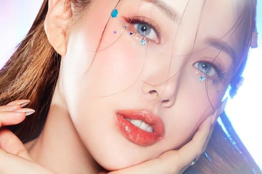 Cận cảnh khuôn mặt người với trang điểm mắt sáng tạo và đôi môi bóng.