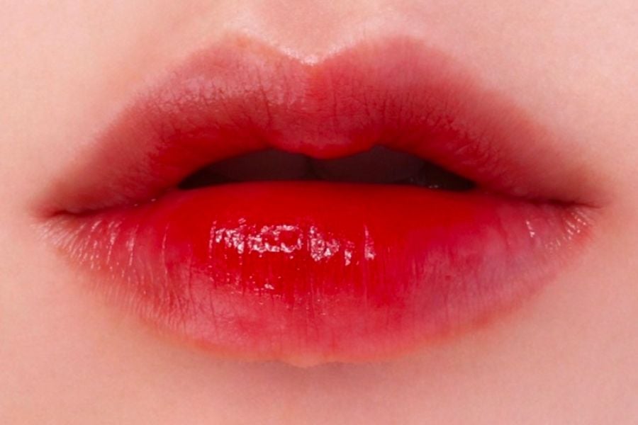 Đôi môi được tô son đỏ, bóng và căng mọng, chiếm trọn khung hình.