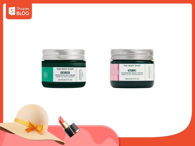 Hai hộp kem dưỡng da của The Body Shop trên nền trắng, góc trái có thêm mũ và son môi.