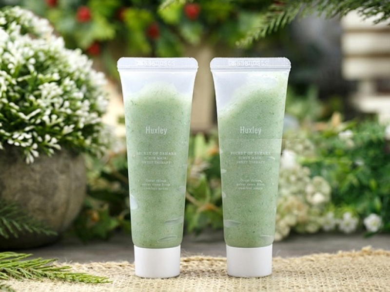 2b934708-tay-te-bao-chet Hai tuýp mỹ phẩm màu xanh lá trên nền cây xanh, đặt trên bề mặt vải thô.