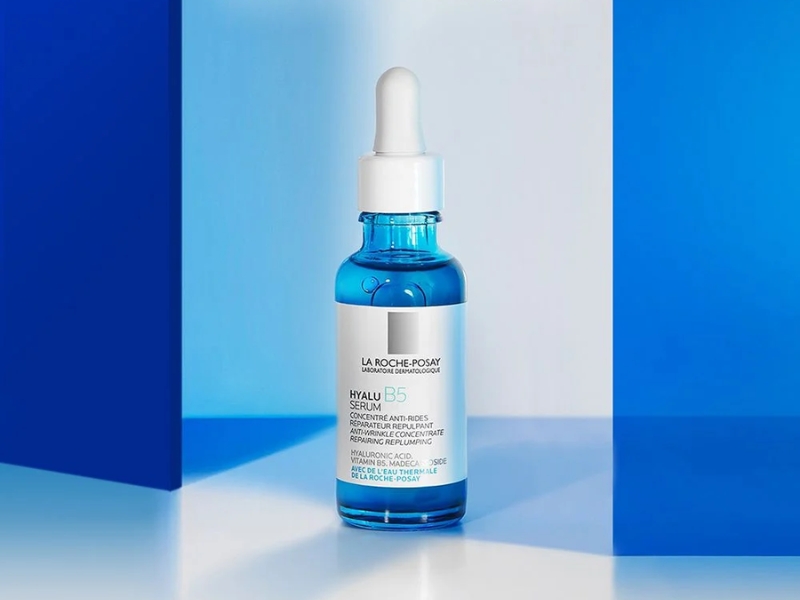 3075f797-serum-cho-da-hon-hop-thien-dau-2 Chai serum màu xanh có ống nhỏ giọt, đặt trên nền xanh trắng.