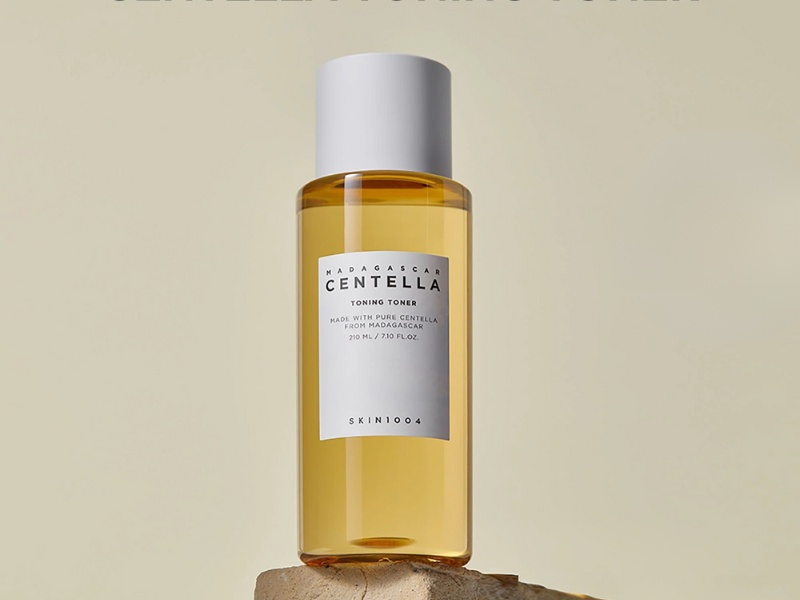 Chai toner màu vàng nhạt, nhãn hiệu Madagascar Centella, dung tích 210 ml, đặt trên nền màu trung tính.