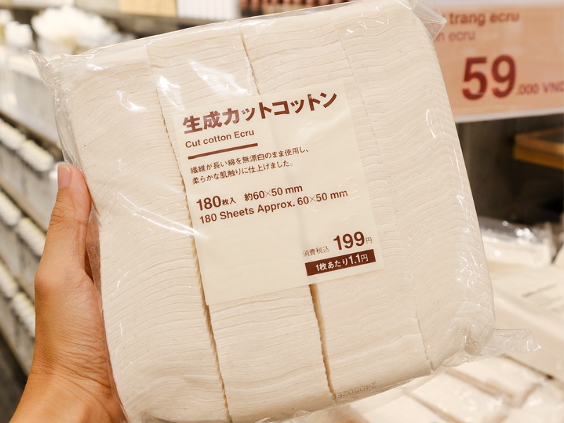 434666b6-bong-tay-trang-tot-cho-dau-da-mun-12 Gói bông cắt sẵn màu ecru, 180 miếng, kích thước 60x50mm, được cầm trên tay trong cửa hàng.