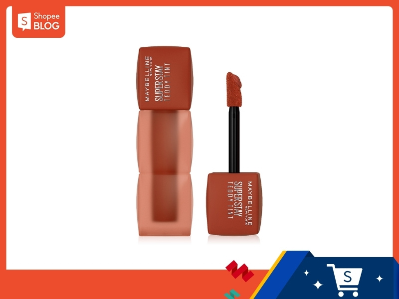 45f7cdd4-review-son-maybelline-11 Son kem màu nâu cam với thiết kế vuông vắn, gồm một lọ son và một cọ có đầu chổi.