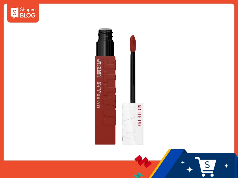 469e0489-review-son-maybelline-26 Son kem lì màu đỏ nâu với đầu cọ, đặt trên nền trắng và viền cam.