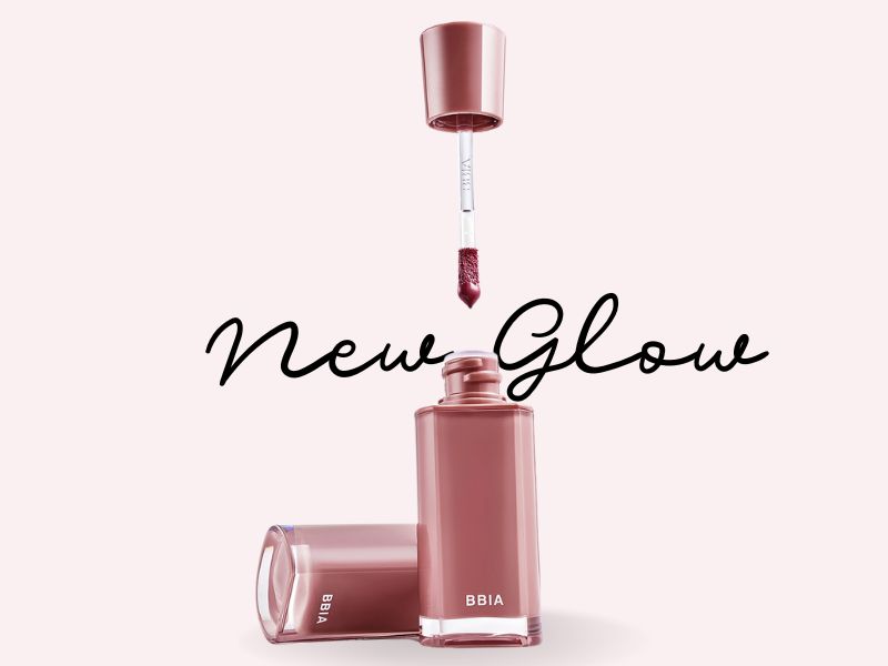 6868ed75-son-mau-hong-dat-dep-11 Hình ảnh chai son màu hồng nâu với cọ son và chữ "New Glow" trên nền hồng nhạt.