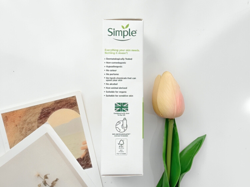 6a4a7bca-kem-duong-am-cho-da-mun-10 Hộp sản phẩm chăm sóc da Simple bên cạnh hoa tulip và hai tấm hình nghệ thuật trên nền trắng.