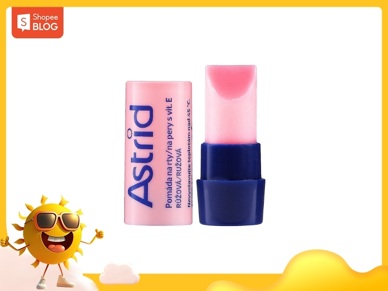 7424f66a-son-duong-astrid-co-tot-khong-7 Thỏi son dưỡng môi màu hồng và xanh dương trên nền trắng với viền vàng, có logo ở góc trái.