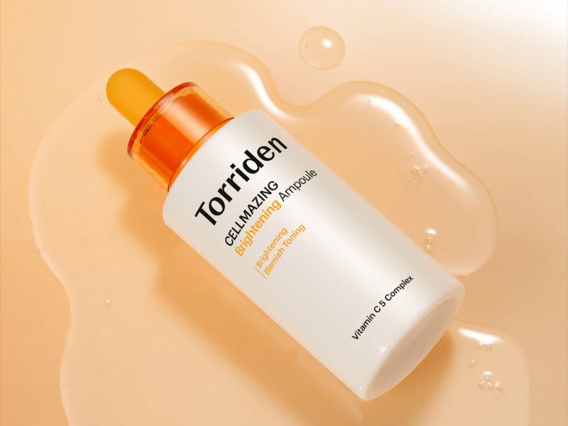 8962d6c2-serum-lam-deu-mau-da-11 Chai serum có ống nhỏ giọt màu cam trên nền chất lỏng màu cam nhạt, nhãn hiệu Torriden.