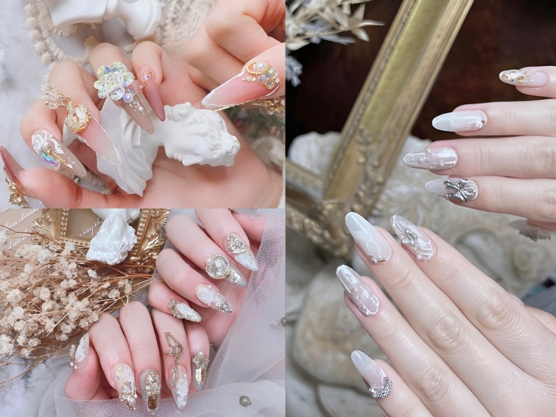 Bộ móng tay được trang trí cầu kỳ với họa tiết và phụ kiện lấp lánh, nền trắng ngọc trai.