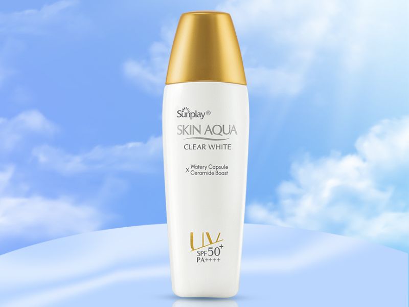 8fc3dec8-review-kem-chong-nang-skin-aqua2 Chai kem chống nắng Sunplay Skin Aqua Clear White, nắp vàng, nền trời xanh và mây trắng.