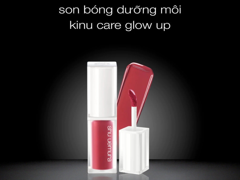 9eaecf0a-review-son-shu-uemura-8 Son bóng dưỡng môi màu đỏ với nắp mở, nền đen, có chữ "son bóng dưỡng môi kinu care glow up".