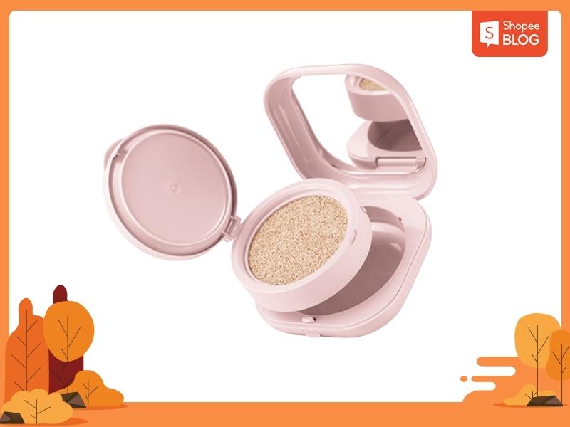 9f0350c3-cushion-cho-da-kho-7 Hộp phấn nước màu hồng mở nắp, có gương bên trong, đặt trên nền trắng với khung viền trang trí mùa thu.