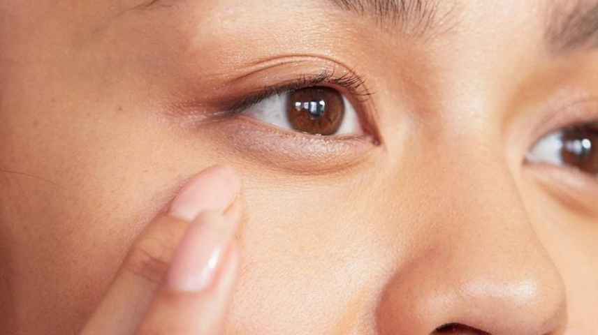 Hướng Dẫn Trang Điểm Giấu Bọng Mắt Hiệu Quả Giúp Tăng Sự Tự Tin 3 Người đang chạm vào vùng da gần mắt, thể hiện sự chăm sóc da mặt cẩn thận và tỉ mỉ.