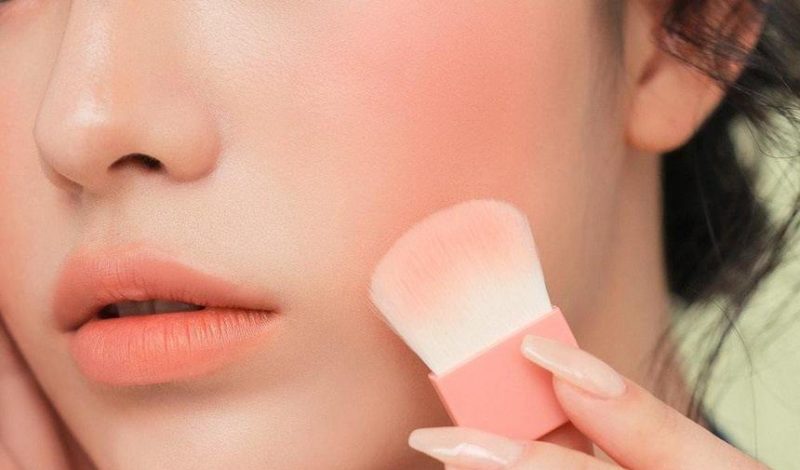 Bí Quyết Trang Điểm Hút Hồn: Cách Làm Nổi Bật Vẻ Đẹp Của Bạn 4 Cận cảnh khuôn mặt với cọ trang điểm đang đánh phấn má hồng, tạo điểm nhấn cho làn da.