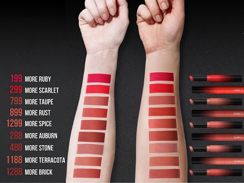 b40132e6-review-son-maybelline-19 Hai cánh tay với các mẫu son màu khác nhau trên da, bên cạnh là hình ảnh các thỏi son tương ứng.