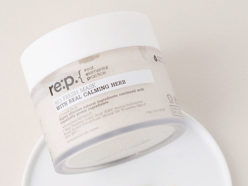 ca077c14-5 Hũ mặt nạ dưỡng da màu trắng, nhãn ghi "BIO FRESH MASK WITH REAL CALMING HERB", đặt trên đĩa trắng.