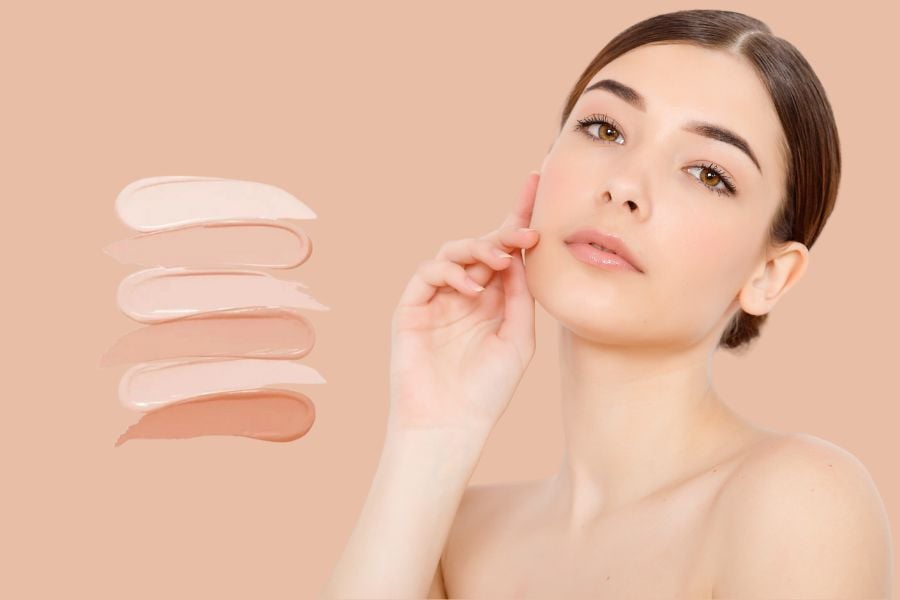 Người phụ nữ chạm mặt, nền màu da, có bốn mẫu màu kem trang điểm bên trái.