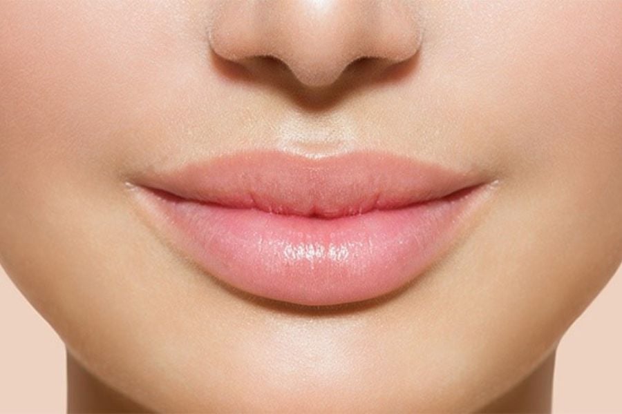 Cận cảnh đôi môi tự nhiên với màu hồng nhạt, làn da mềm mại và mịn màng.