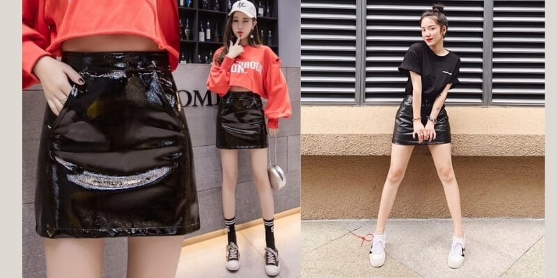 Người mẫu mặc chân váy đen bóng, áo thun và giày thể thao, tạo dáng trước cửa hàng và tường ngoài trời.