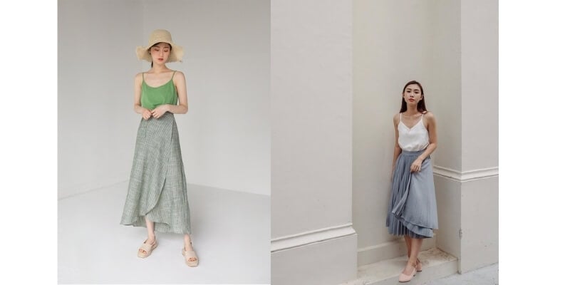 Hai người mẫu nữ mặc váy dài và áo hai dây, tạo dáng trong không gian sáng sủa.