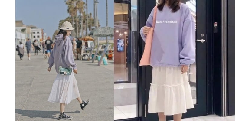 Người mặc áo hoodie tím và váy trắng, đi dạo ngoài trời và đứng trong nhà, cầm túi xách.