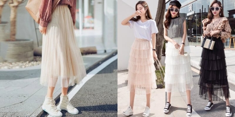 Ba người mặc váy dài và giày thể thao đứng trên phố, thể hiện phong cách thời trang hiện đại và năng động.