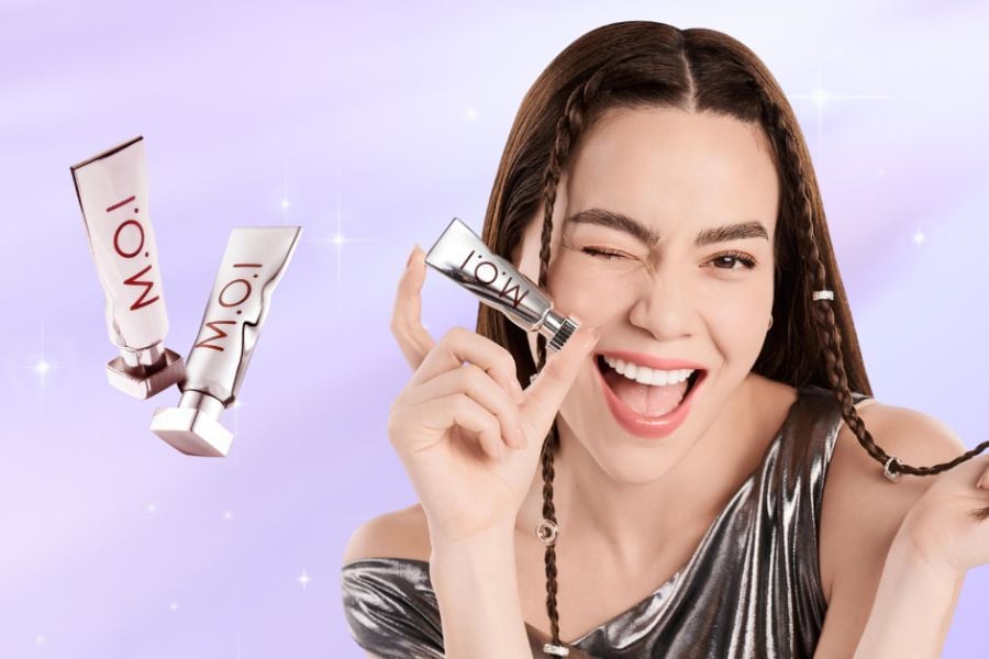 Người phụ nữ cầm sản phẩm mỹ phẩm, nền tím lấp lánh.