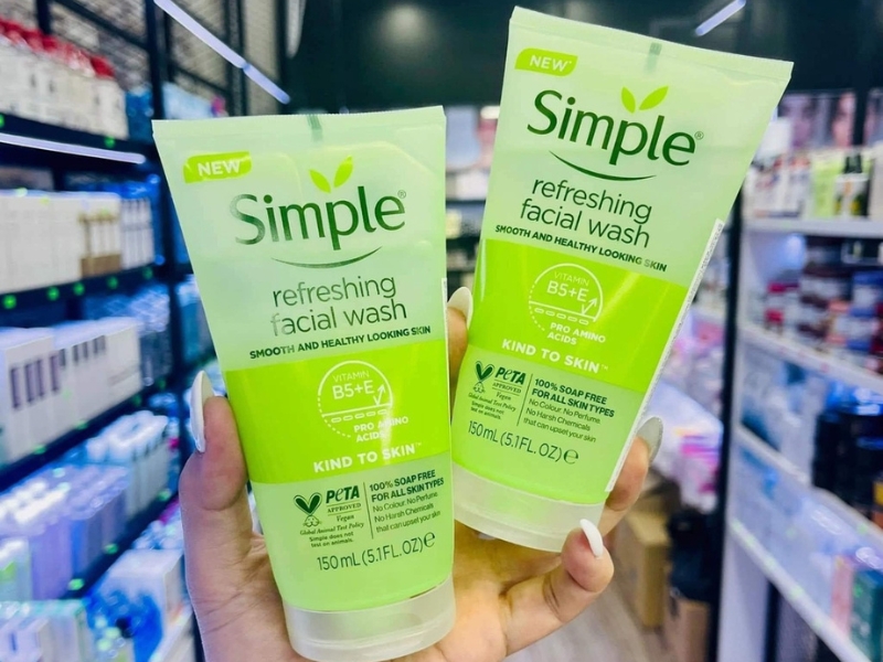 d0d3a9d5-sua-rua-mat-cho-da-hon-hop-thien-kho-9 Hai sản phẩm sữa rửa mặt Simple được cầm trên tay trong cửa hàng mỹ phẩm, nền là kệ hàng.