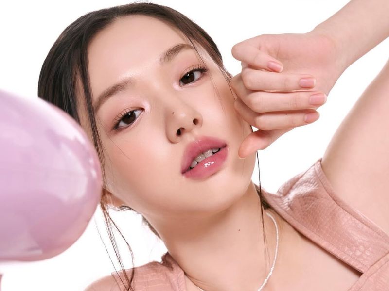 db4538f5-son-mau-hong-dat-dep-8 Người mẫu tóc đen tạo dáng trước máy ảnh, nền trắng, mặc áo không tay màu hồng nhạt.