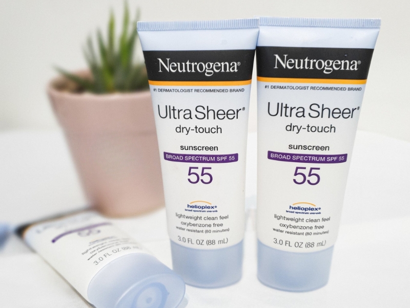 e87e9908-kem-chong-nang-duong-am-30 Hai tuýp kem chống nắng SPF 55 đặt cạnh nhau, phía sau là một chậu cây nhỏ.