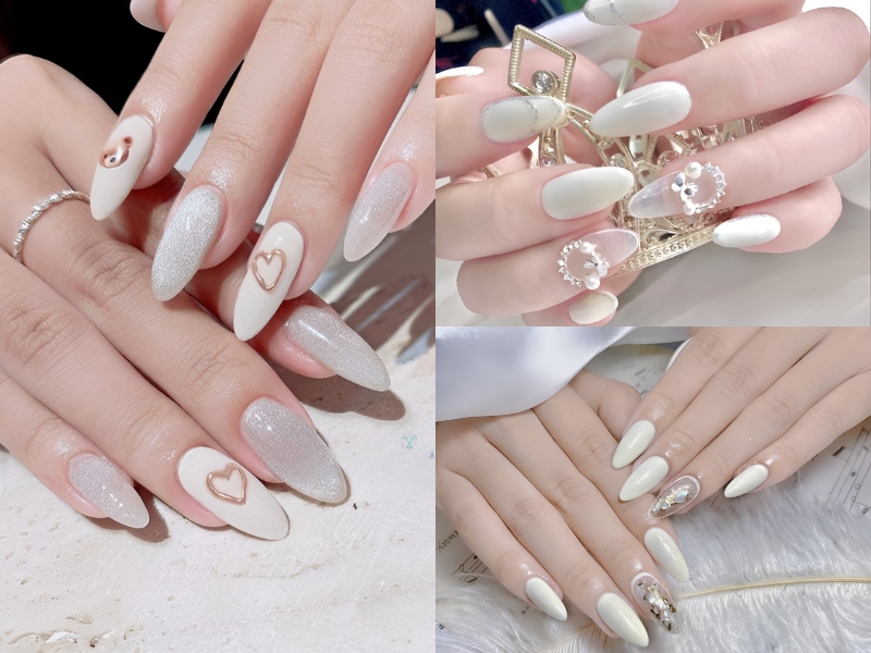 Bộ móng tay màu trắng và bạc với các họa tiết trang trí khác nhau, bao gồm trái tim và hình đính đá.