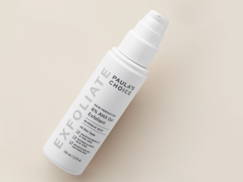 eb8ca899-paulas-choice Chai tẩy tế bào chết dạng gel AHA 8% màu trắng nằm nghiêng trên nền màu be.