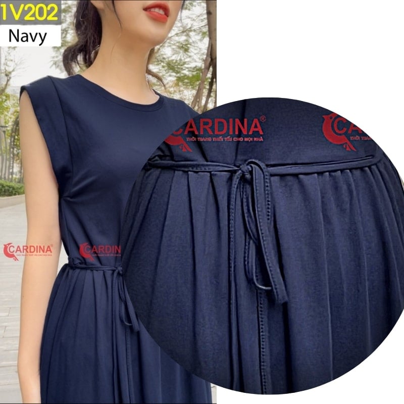 Người mẫu mặc váy màu xanh navy, có chi tiết dây thắt eo. Hình ảnh phóng to chi tiết váy.