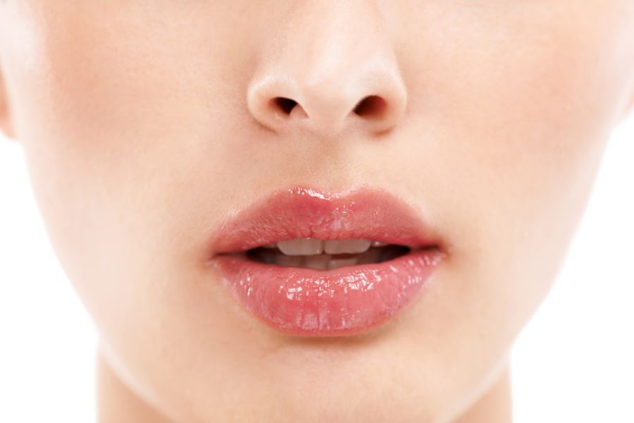 Cận cảnh đôi môi hồng bóng của một người, với làn da mịn màng, không xác định danh tính.