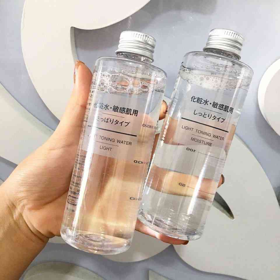 my-pham-muji-2 Hai chai nước hoa hồng trong suốt, có nhãn chữ Nhật và Anh, được cầm trên tay.