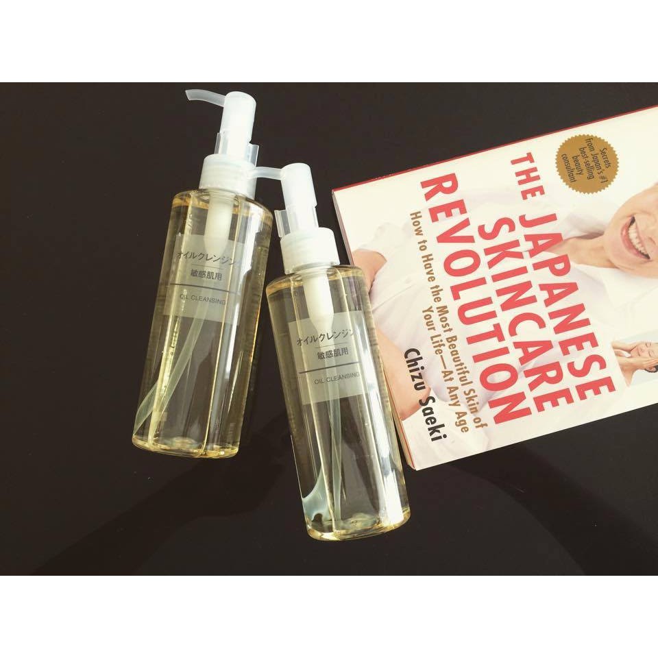 my-pham-muji-3 Hai chai dầu tẩy trang cùng một cuốn sách về chăm sóc da trên nền đen.