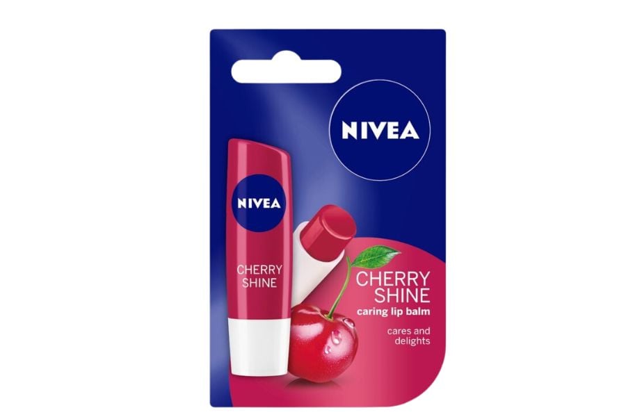 Son dưỡng môi hương cherry trong bao bì, có hình quả cherry và nhãn hiệu nổi bật trên nền xanh và đỏ.