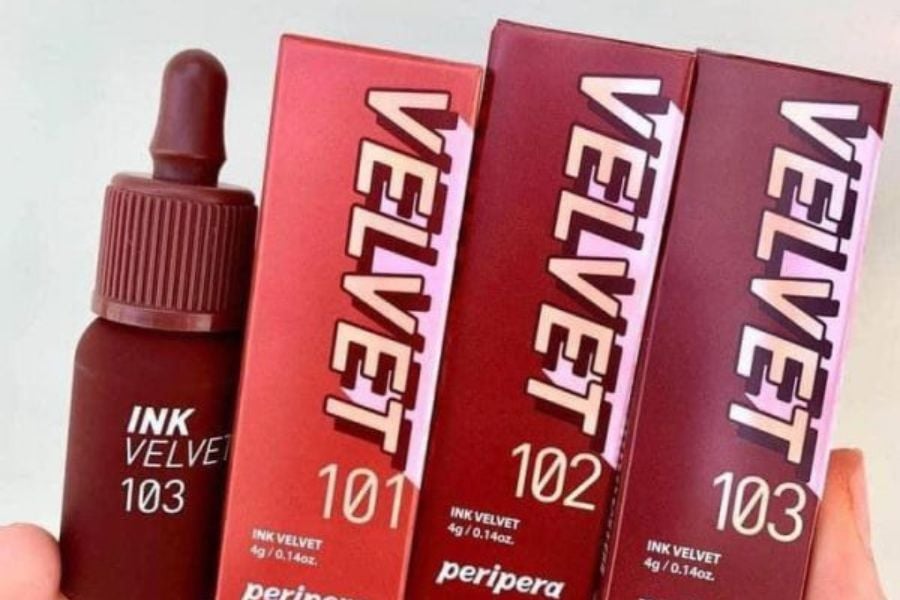Ba hộp son và một lọ son dạng lỏng màu đỏ, nhãn "VELVET" và các số 101, 102, 103.