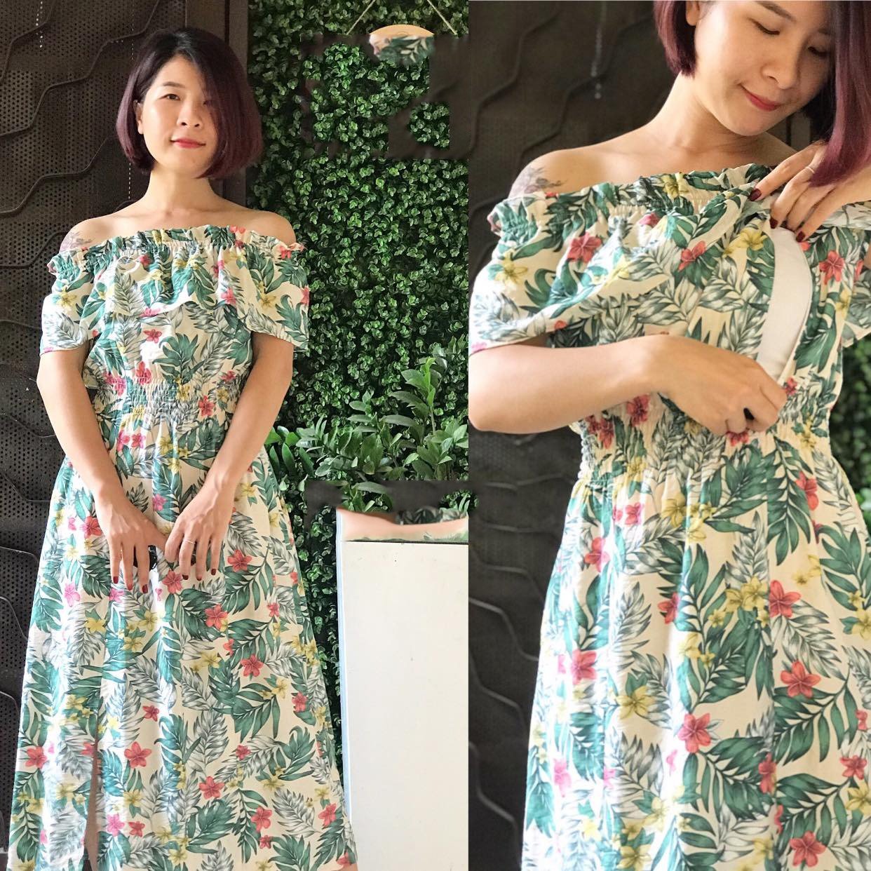 Người mặc váy hoa trễ vai đứng cạnh bức tường cây xanh.