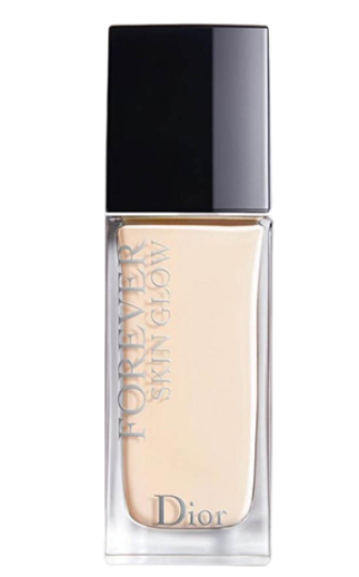 Chai lọ thủy tinh chứa chất lỏng màu be nhạt, nắp màu đen, có chữ "Forever Skin Glow" in trên thân chai.