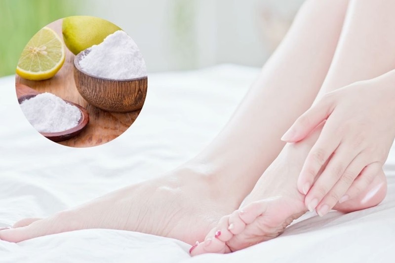 Đôi bàn chân trên nền trắng, cạnh đó là hình tròn chứa bột trắng và chanh tươi trong bát gỗ.