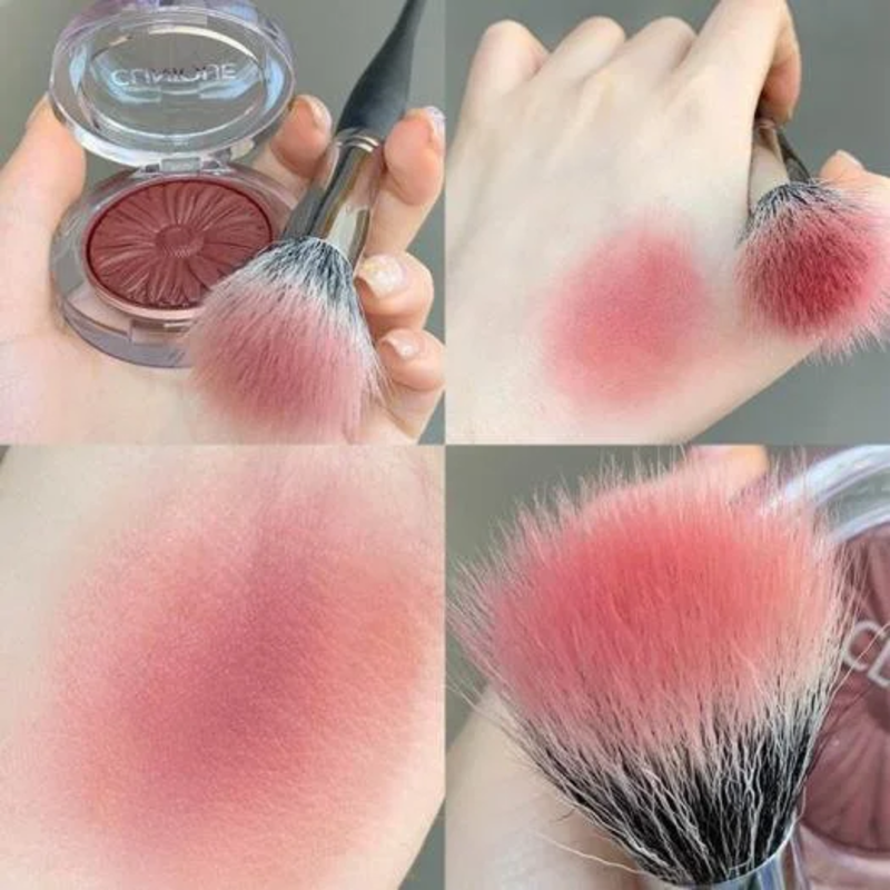 Phấn má hồng và cọ trang điểm trên tay, một vết phấn được thử trên da, cận cảnh cọ với lông màu hồng.