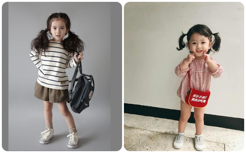 Hai bé gái mặc trang phục dễ thương, tóc buộc hai bên, đứng tạo dáng trước máy ảnh.