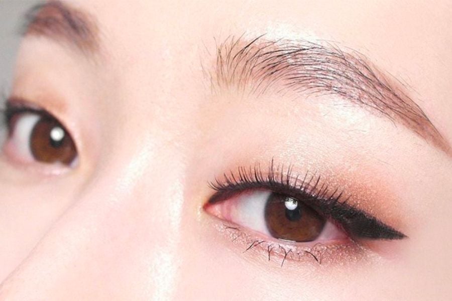 Cận cảnh đôi mắt với lớp trang điểm mắt và đường kẻ eyeliner, lông mày gọn gàng.