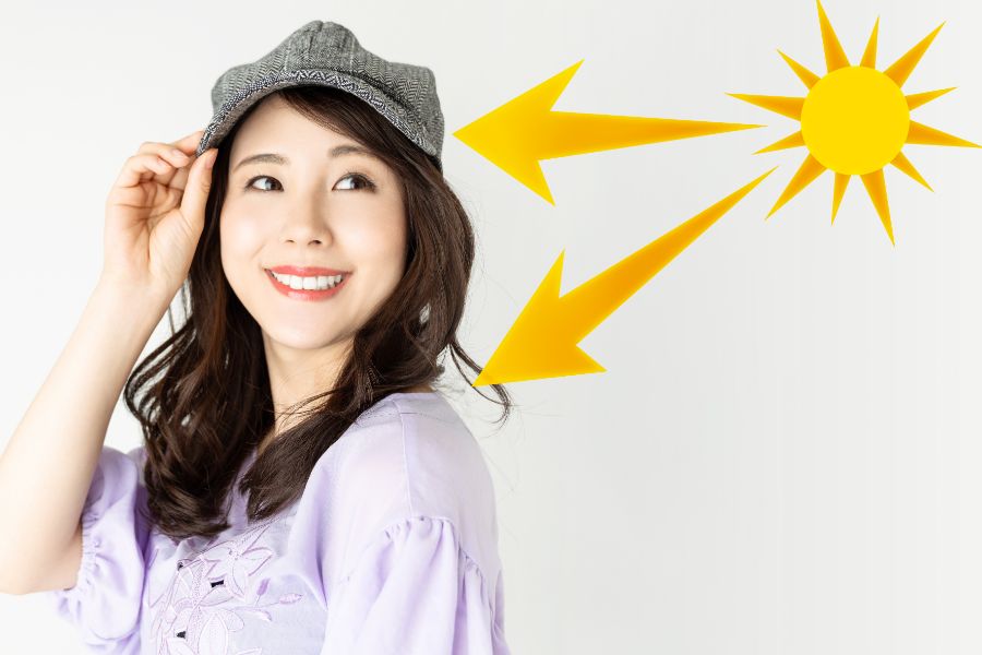 Người đội mũ xám mỉm cười, đứng dưới ánh nắng với mũi tên chỉ hướng từ mặt trời.