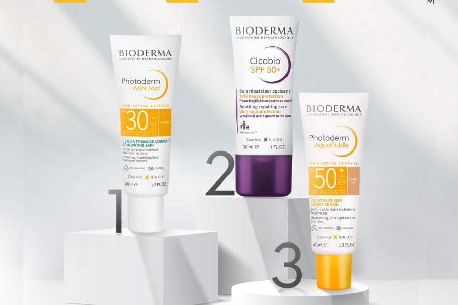 Ba chai kem chống nắng Bioderma với các chỉ số SPF khác nhau được đặt trên nền trắng.